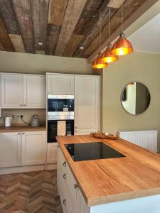 Una cocina con gabinetes blancos y una encimera de madera. en Villa Rose-Spacious Home with beautiful garden, en Saint Annes on the Sea