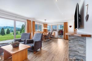 a living room with a fireplace and a table and chairs at Cafe-Restaurant-Gästehaus Waldvogel in Feldberg