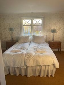 a white bed with two towels on it in a bedroom at Kuskens svit in Gränna