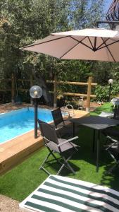a table and chairs and an umbrella next to a pool at La Vista Sul Golfo in Massa Lubrense