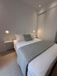 a bedroom with a white bed and a window at Drop off in Ermoupoli