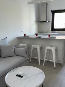 a living room with a couch and a table and a kitchen at Drop off in Ermoupoli +5 photos