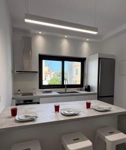 a kitchen with a counter with chairs and a window at Drop off in Ermoupoli