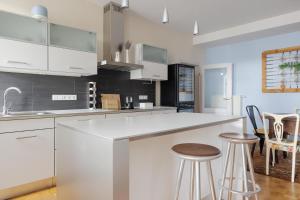 a kitchen with white cabinets and bar stools at Boardinghouse siebzehn82 in Endingen