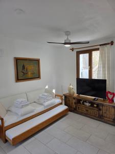 a living room with a couch and a flat screen tv at Sevinc Papatya House in Milas