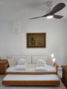 a living room with a couch and a ceiling fan at Sevinc Papatya House in Milas