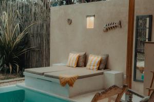 a bench with two pillows on a patio at Monkey Suites in Diani Beach