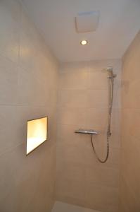 a bathroom with a shower with a light on the wall at Hotel Feiden Garni in Ediger-Eller