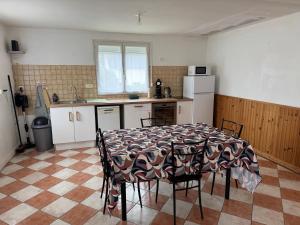 a kitchen with a table and chairs in a room at La petite Varenne 28 in La Chapelle-du-Noyer