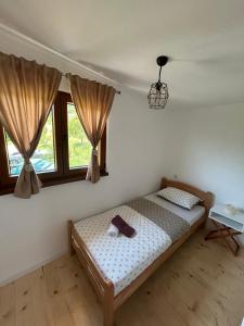 a bedroom with a bed and two windows at Vikendica Diva in Varvara