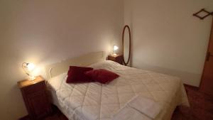 una camera da letto con un letto bianco con due lampade di Il Pianello di Badia Prataglia a Badia Prataglia Altre 4 foto