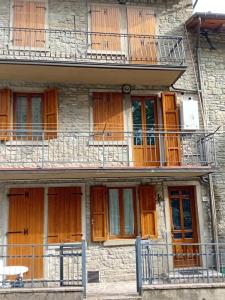 un antico edificio con porte in legno e balcone di Il Pianello di Badia Prataglia a Badia Prataglia