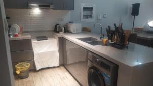 a kitchen with a sink and a washing machine at Private One bedroom and a Hall in Dubai