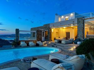 a villa with a swimming pool at night at Villa Tavani Agios Ioannis Mykonos in Agios Ioannis Mykonos