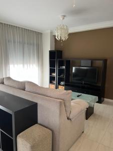 salon z kanapą i telewizorem z płaskim ekranem w obiekcie APARTAMENTO LA PERLA w mieście Portonovo