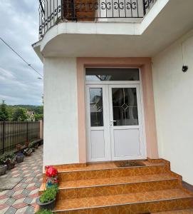 a white door on a house with stairs at Casa Primaverii in Râşnov +8 photos