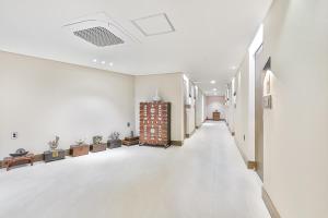an empty hallway of a building with white walls at Hotel Onggi in Gyeongju +50 photos