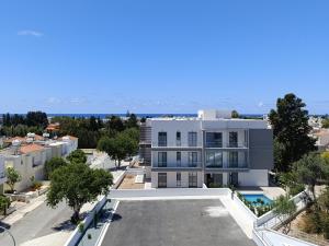 an aerial view of a white building with a pool at Blue Oasis Apartment in Nea Paphos