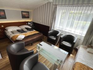 a hotel room with a bed and a table and chairs at AbWentur Pokoje in Gdańsk