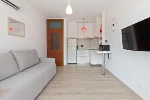 un salon avec un canapé et une cuisine dans l'établissement Apartment DV Magnolia, à Tivat