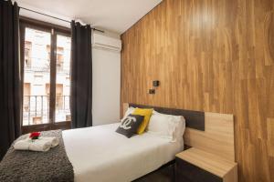A bed or beds in a room at Apartamentos Day Madrid CHUECA Centro Gran Via Sol Malasaña