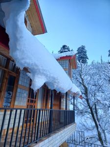 a pile of snow on a balcony of a house at Heavens Orchard in Manāli