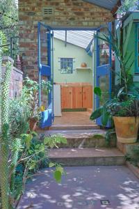 ein Haus mit blauer Tür und einigen Pflanzen in der Unterkunft Forest Haven in Harare