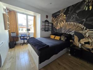 a bedroom with a bed and a table in it at Maison design aux portes de Paris in Puteaux
