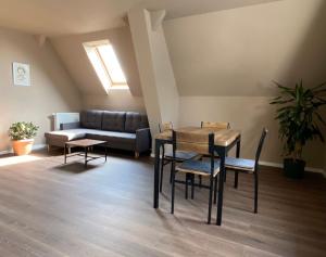 a room with a table and chairs and a couch at Ferienwohnungen Lily, Bärwalder See, Ferienwohnung "UHYST" in Boxberg
