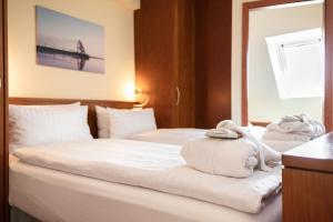 a hotel room with two beds with towels on them at Hotel Atlantic Juist in Juist +37 photos