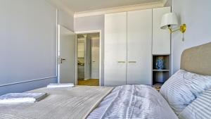 Un dormitorio con una cama grande y un armario. en Rezydencja Niechorze D212 Classik - 5D Apartments, en Niechorze