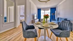 Un comedor con mesa y sillas en Rezydencja Niechorze D212 Classik - 5D Apartments, en Niechorze