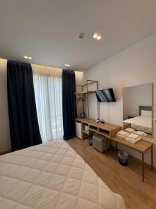 a large bedroom with a large bed and a desk at Otto Hotel in Ksamil