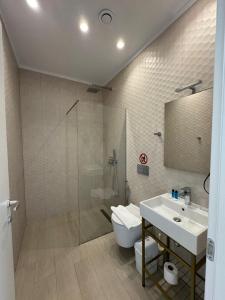 a bathroom with a sink and a shower and a toilet at Otto Hotel in Ksamil