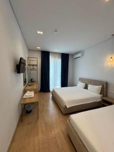 a hotel room with two beds and a table at Otto Hotel in Ksamil