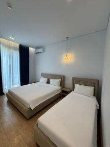 two beds in a hotel room with two beds sidx sidx sidx at Otto Hotel in Ksamil