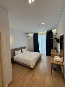 a bedroom with a bed and a desk in it at Otto Hotel in Ksamil