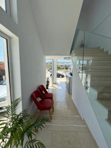 a red chair sitting on a staircase in a house at Otto Hotel in Ksamil