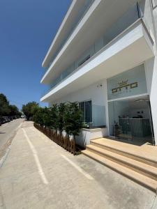 a building with potted plants in front of it at Otto Hotel in Ksamil