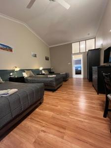 a living room with two beds and a couch at Airlie House Motor Inn in Scone