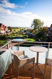 a balcony with a table and chairs and a view at Hotel Atlantic Juist in Juist