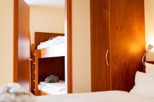 a reflection of a bedroom with a bunk bed and a mirror at Hotel Atlantic Juist in Juist