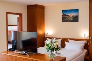 a hotel room with a television and a bed at Hotel Atlantic Juist in Juist