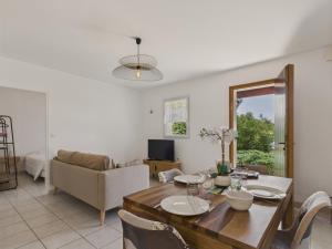 une salle à manger et un salon avec une table et des chaises dans l'établissement Jolie maison pour 4 personnes avec jardin, à Saint-Vincent-sur-Jard