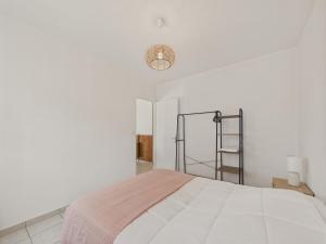 - une chambre blanche avec un lit et une lampe dans l'établissement Jolie maison pour 4 personnes avec jardin, à Saint-Vincent-sur-Jard