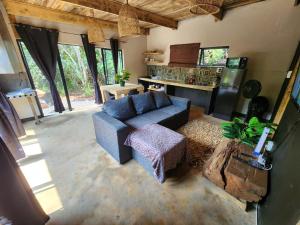a living room with a blue couch and a kitchen at Hartbeest Bush Lodge 27 in Hartbeespoort