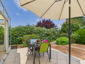 une table et des chaises avec un parasol sur une terrasse dans l'établissement Jolie maison pour 4 personnes avec jardin, à Saint-Vincent-sur-Jard