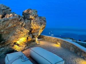 a bed on the side of a rock cliff at Villa Tavani Agios Ioannis Mykonos in Agios Ioannis Mykonos +56 photos