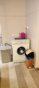 a washing machine in a room with a trash can at 3 Brothers IV in Tríkala