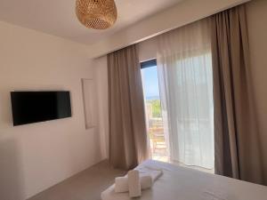 a bedroom with a bed and a large window at Villa Calliope in Himare